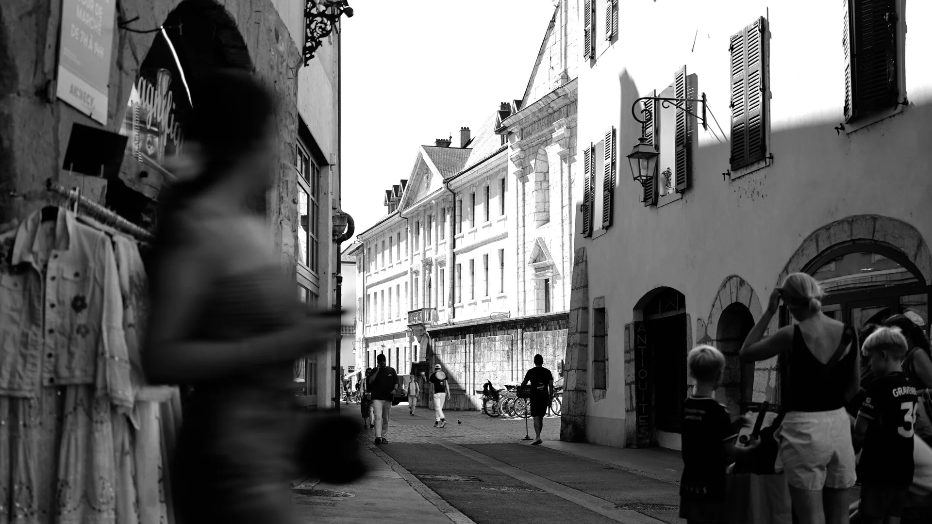Mensen wandelen door een zonnige straat in een Europese stad