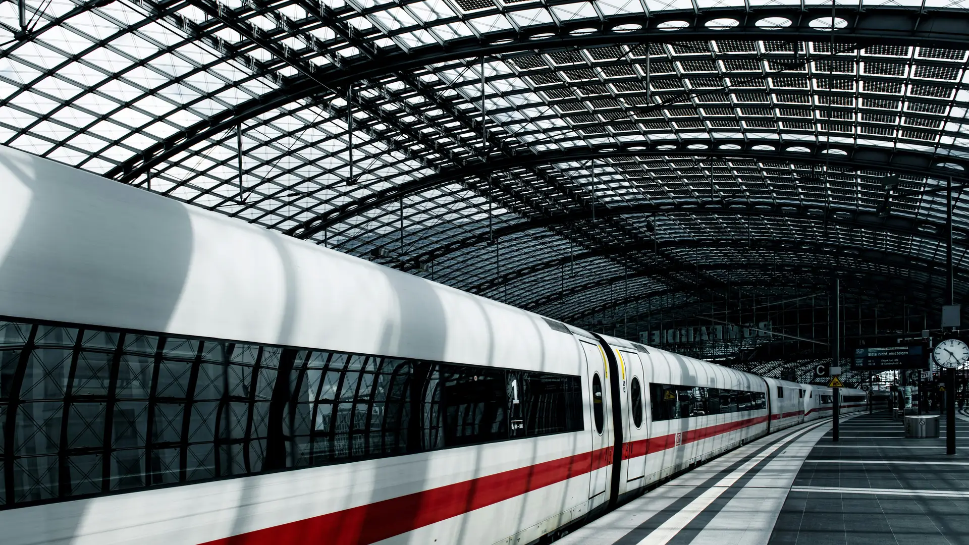 Wit met rode hogesnelheidstrein rijdt een station binnen